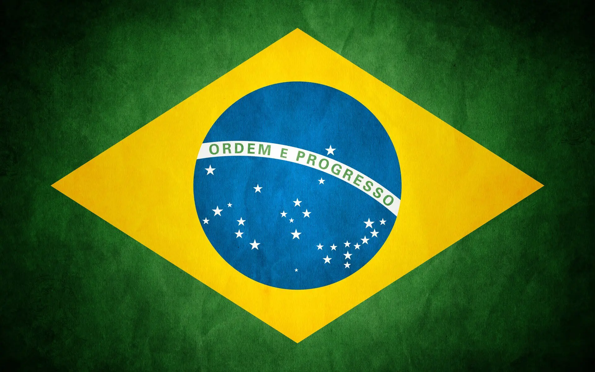 The image shows the Brazilian flag featuring a green field with a yellow diamond at the center. Inside the diamond is a blue globe with white stars and the banner Ordem e Progresso.