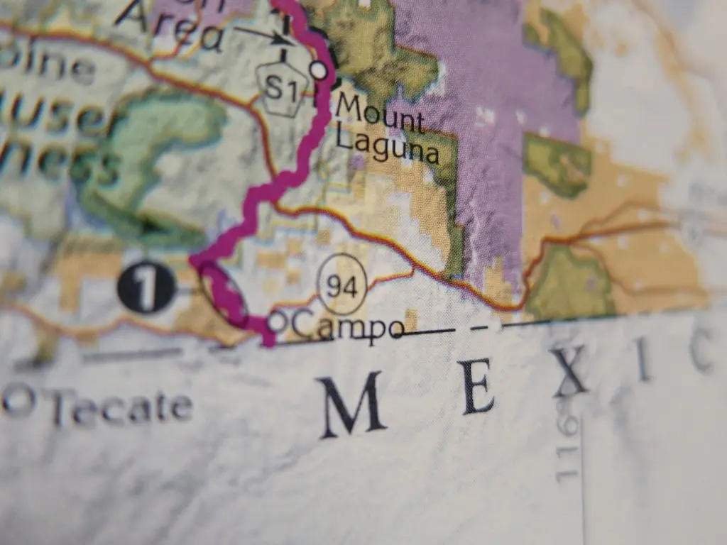 Close-up of a map detailing areas near the Mexico-U.S. border, where the PCT weaves through. Highlighted locations include Tecate, Campo, and Mount Laguna. The colorful regions, roads, and prominent border line capture the urgency with just one week left in crunch time for trekkers.