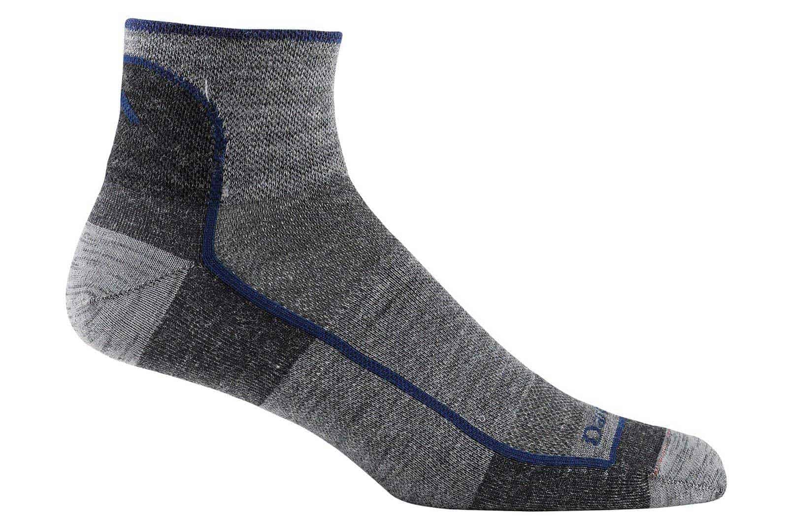 A single gray ankle sock with darker gray and black accents. This darn tough sock features a blue seam line along its side, complemented by blue detailing on the cuff and toe area.