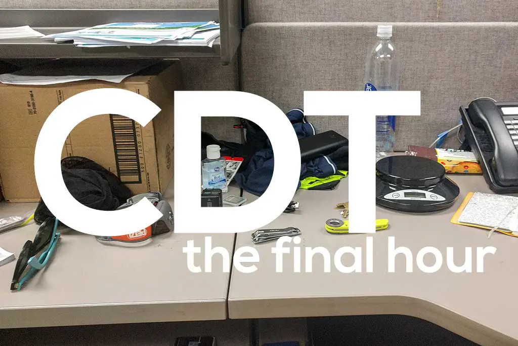 A cluttered office desk with various items like sunglasses, water bottle, scale, and papers. Large white text overlay reads, Countdown to the final hour on the Continental Divide Trail.
