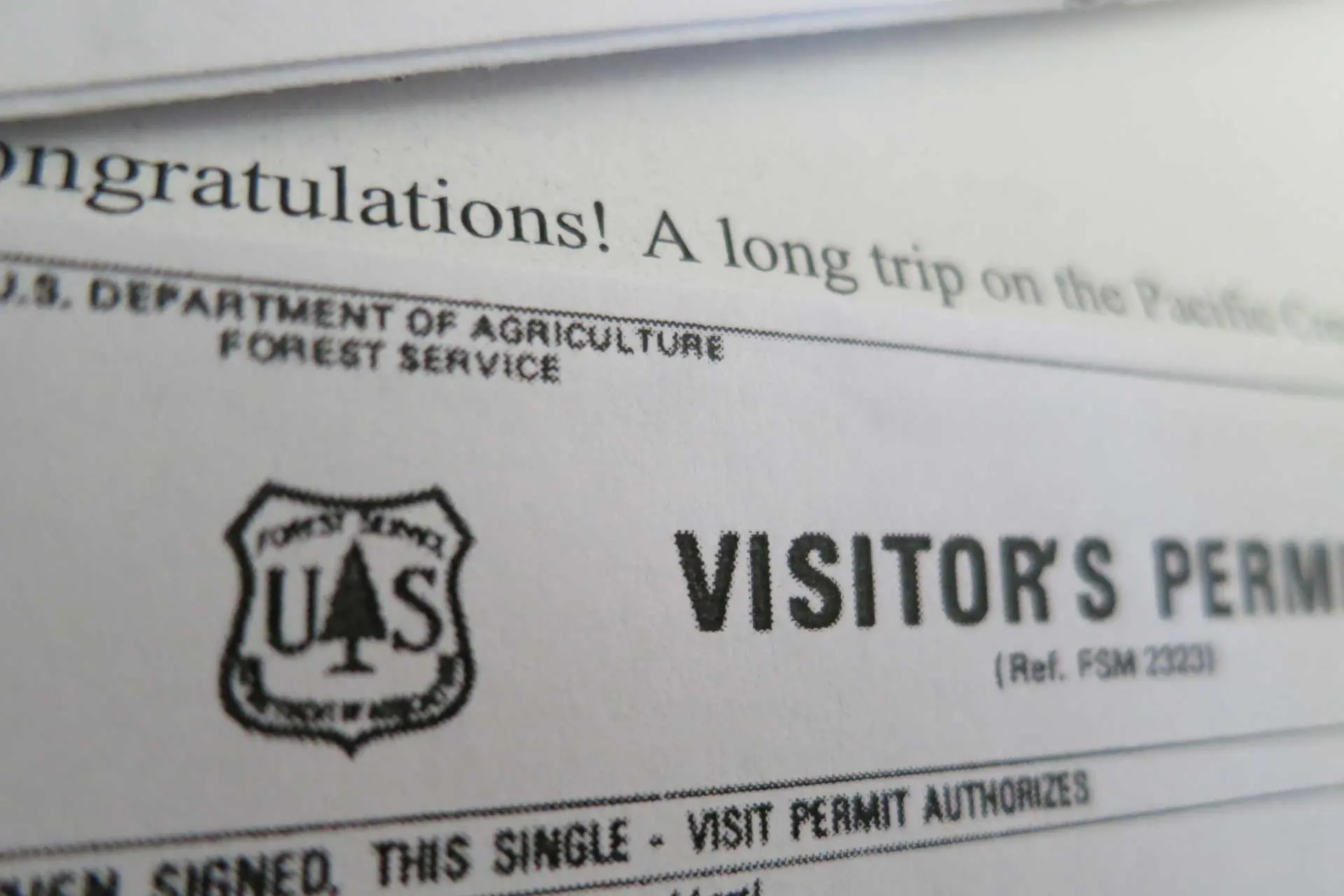 Close-up of a U.S. Forest Service visitors permit document. Congratulations! stands out above the text that outlines the permit details and PCT permit rules, with the Forest Service logo displayed prominently.
