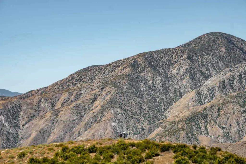 A hiker uses an umbrella in Whitewater Preserve after crossing I-10 in Cabazon.