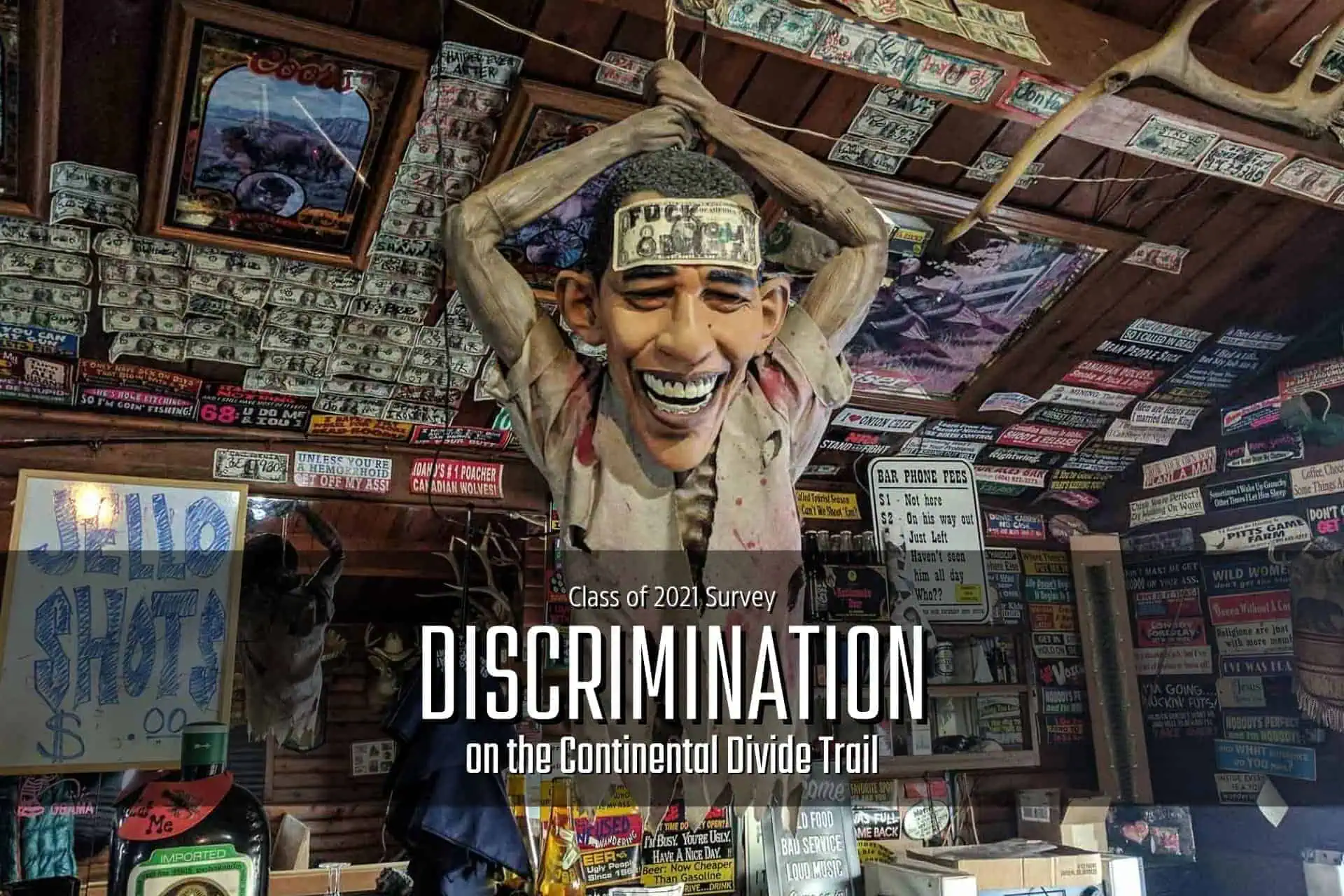 A room plastered with signs and stickers adorns the walls and ceiling. A mannequin with outstretched arms, cartoonish face, and a headband stands sentinel. The text reads, Class of 2021 Survey: CDT Discrimination on the Continental Divide Trail.