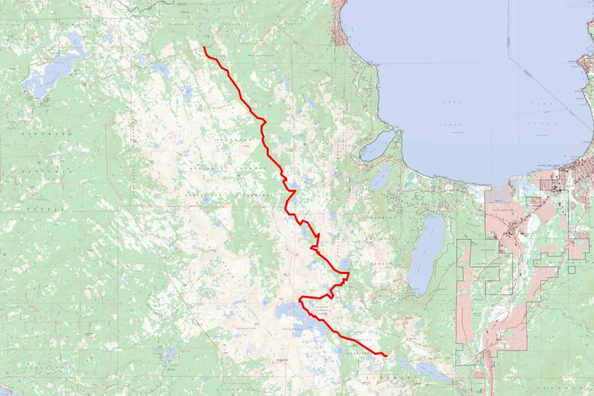 A detailed map shows a red line winding through green and beige terrain, indicating a trail or path. The route starts near a large blue body of water and passes several smaller lakes and patches of forested areas, reminding hikers to observe Bear Canister Regulations in Desolation Wilderness.