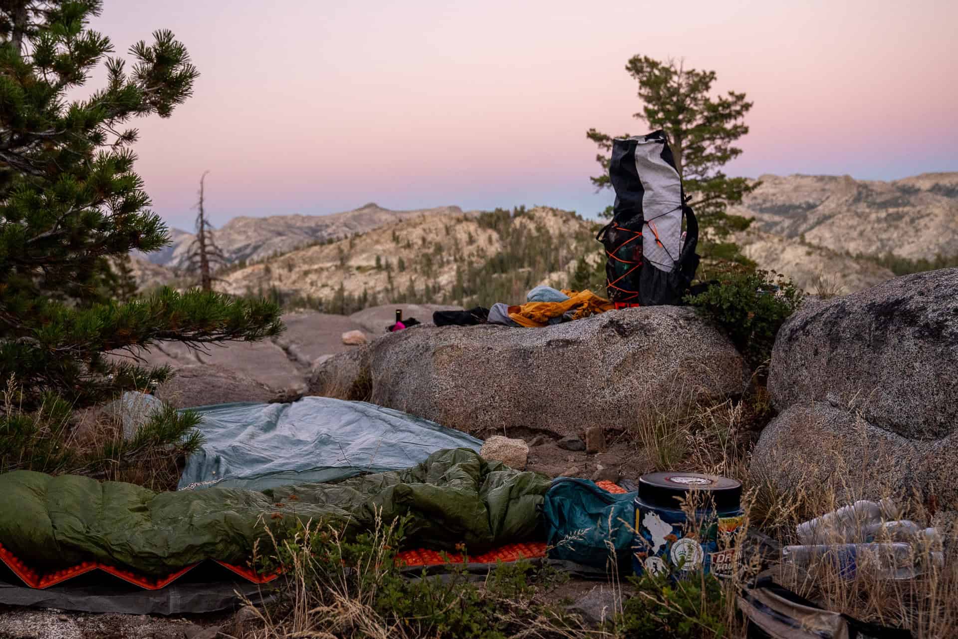 A backpack on a rock with a sunset in the background