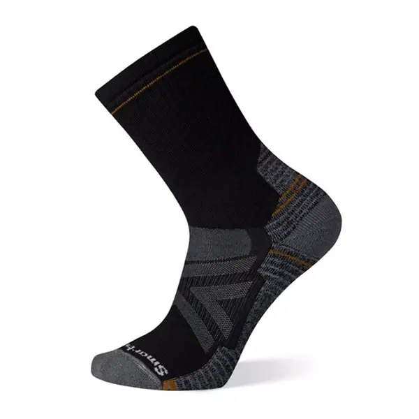 A single black and gray athletic sock with orange accents, featured in the JMT Gear Guide 2024. The sock boasts a cushioned heel and toe, ribbed cuff, and geometric side patterns. Its elegantly displayed at an angle against a plain white background.